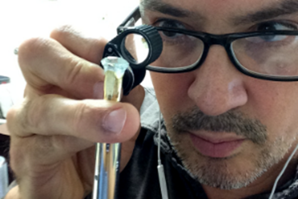 Award-winning gemcutter, Clay Zava, inspects his next gem!