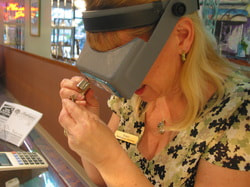 Tracy inspects a ring at your Masterpiece Jewelers. 